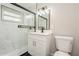 This bathroom has a glass enclosed shower with marble tile and vanity with a black faucet and light fixture at 3213 Normandy Dr, Port Charlotte, FL 33952