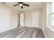 This bedroom features grey laminate floors, three closets, a ceiling fan and neutral colored walls at 3213 Normandy Dr, Port Charlotte, FL 33952