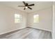 This bedroom features grey laminate floors, two windows, a ceiling fan and neutral colored walls at 3213 Normandy Dr, Port Charlotte, FL 33952