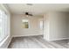 Bright living room with gray wood-look floors, neutral walls, a ceiling fan, and natural light at 3213 Normandy Dr, Port Charlotte, FL 33952