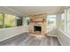 Cozy sun room featuring brick fireplace, gray floors, and ample natural light at 3213 Normandy Dr, Port Charlotte, FL 33952