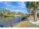 Backyard view of waterfront with private dock, tropical landscaping, and serene water views at 3415 Knox Ter, Port Charlotte, FL 33948