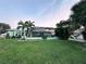 The back exterior offers a screened lanai and a private, green backyard, excellent for outdoor living at 399 Bal Harbor Blvd, Punta Gorda, FL 33950