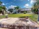 Backyard view showcasing the patio, lush lawn, mature trees, and canal access at 399 Bal Harbor Blvd, Punta Gorda, FL 33950
