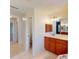 Well-lit hallway bathroom with neutral tile flooring, wood vanity and cabinet storage at 399 Bal Harbor Blvd, Punta Gorda, FL 33950