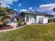 Green home with a lush lawn, mature landscaping, and a screened-in lanai at 399 Bal Harbor Blvd, Punta Gorda, FL 33950