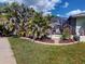 Landscaped backyard featuring tropical plants, a patio, and a screened-in lanai at 399 Bal Harbor Blvd, Punta Gorda, FL 33950