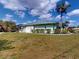 Single-story home featuring a lush green lawn and mature palm trees at 399 Bal Harbor Blvd, Punta Gorda, FL 33950