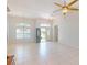 Bright and airy living room with tile flooring, ceiling fan, and natural light from the front door at 399 Bal Harbor Blvd, Punta Gorda, FL 33950