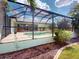 Large screened-in pool area with outdoor kitchen, lounge chairs, and tropical landscaping at 399 Bal Harbor Blvd, Punta Gorda, FL 33950