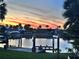 Beautiful waterfront view featuring a boat lift, serene water, and a stunning sunset sky backdrop at 399 Bal Harbor Blvd, Punta Gorda, FL 33950