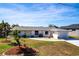 Charming single-story home with a well-manicured lawn, tidy landscaping, and a yellow front door at 4051 Rock Creek Dr, Port Charlotte, FL 33948