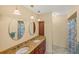 Bright bathroom with double vanity, granite countertops, stylish lighting, and a shower at 611 Bal Harbor Blvd, Punta Gorda, FL 33950