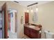 Bathroom vanity with updated fixture, round mirror, and a storage closet at 611 Bal Harbor Blvd, Punta Gorda, FL 33950
