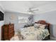Cozy bedroom features a decorative ceiling fan, a window, and tropical print bedding at 611 Bal Harbor Blvd, Punta Gorda, FL 33950