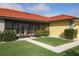 Charming home with a red tile roof, well-manicured lawn, and mature landscaping at 611 Bal Harbor Blvd, Punta Gorda, FL 33950