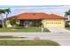 Charming single-story home featuring a well-manicured lawn, orange tile roof, and attached two car garage at 611 Bal Harbor Blvd, Punta Gorda, FL 33950