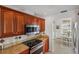 Modern kitchen featuring dark wood cabinets, granite counters, stainless microwave, and a view to the dining area at 611 Bal Harbor Blvd, Punta Gorda, FL 33950