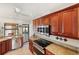 Well-lit kitchen featuring dark wood cabinets, stainless appliances, and a view into the dining area at 611 Bal Harbor Blvd, Punta Gorda, FL 33950