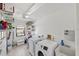 Bright laundry room includes a washer, dryer, utility sink, and lots of shelving at 611 Bal Harbor Blvd, Punta Gorda, FL 33950