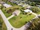Aerial view of a neighborhood showcasing a home with a brick driveway and spacious green lawn at 616 Posadas Cir, Punta Gorda, FL 33983