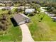 Aerial view of home with paver driveway, green lawn, and surrounding neighborhood at 616 Posadas Cir, Punta Gorda, FL 33983