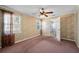 Inviting bedroom featuring two windows, soft carpet, neutral walls, and an overhead ceiling fan at 8035 Hillman Ave, Punta Gorda, FL 33982