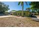 Green home with well kept lawn and minimal landscaping with trees and plants at 8035 Hillman Ave, Punta Gorda, FL 33982