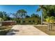 Charming single-story home with a long driveway and lovely yard featuring mature trees and green lawn at 8035 Hillman Ave, Punta Gorda, FL 33982