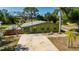 Charming single-story home featuring green exterior with lush landscaping and mature trees at 8035 Hillman Ave, Punta Gorda, FL 33982