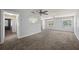 Bright living room with neutral walls, plush carpet, ceiling fans, and large windows creating a inviting space at 8035 Hillman Ave, Punta Gorda, FL 33982