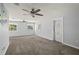 Spacious living room with plush carpet, ceiling fans, neutral walls and large windows creating a bright space at 8035 Hillman Ave, Punta Gorda, FL 33982