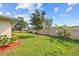 Wide backyard showcasing lush lawn and privacy fence surrounded by colorful mulch beds at 916 S Gondola Dr, Venice, FL 34293