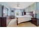 Comfortable bedroom features soft blue walls, plush carpeting, and stylish wood furniture at 916 S Gondola Dr, Venice, FL 34293