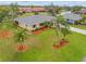 Beautiful home with lush landscaping, featuring palm trees and colorful mulch beds, enhancing its curb appeal at 916 S Gondola Dr, Venice, FL 34293