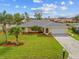 Charming home with a two-car garage, green lawn, and palm tree, enhanced by a well-maintained lawn at 916 S Gondola Dr, Venice, FL 34293