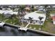 Aerial view of home with a dock on the canal, lush landscaping, and a well-manicured lawn at 931 Bal Harbor Blvd, Punta Gorda, FL 33950