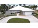 Inviting single-story home featuring a circular driveway, well-manicured lawn, and arched entryway at 931 Bal Harbor Blvd, Punta Gorda, FL 33950