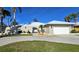 Charming single-story home showcasing a circular driveway, manicured lawn, and unique arched entrance at 931 Bal Harbor Blvd, Punta Gorda, FL 33950