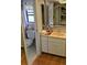 Bathroom featuring sink, mirror, toilet, and a window providing natural light at 22480 Oceanside Ave, Port Charlotte, FL 33952