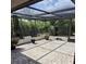 A screened-in patio featuring brick pavers and views of surrounding greenery at 22480 Oceanside Ave, Port Charlotte, FL 33952