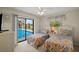 Bright bedroom featuring twin beds and sliding glass doors leading to a screened-in pool area at 1452 Wassail Ln, Punta Gorda, FL 33983