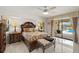 Light-filled main bedroom features a decorative bed, tile flooring and patio access at 1452 Wassail Ln, Punta Gorda, FL 33983