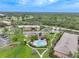 Aerial view showcases lush greenery and mature trees surrounding the community pool and buildings at 1515 Forrest Nelson Blvd # R201, Port Charlotte, FL 33952