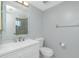 Clean bathroom with white vanity, sink, and toilet, featuring a well-lit mirror at 1515 Forrest Nelson Blvd # R201, Port Charlotte, FL 33952