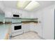 Kitchen featuring white appliances and cabinets with a breakfast bar area at 1515 Forrest Nelson Blvd # R201, Port Charlotte, FL 33952