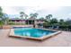 Community pool surrounded by palm trees and lounge chairs for relaxation and recreation at 1515 Forrest Nelson Blvd # R201, Port Charlotte, FL 33952