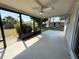 Screened-in back porch with ceiling fan overlooking a large yard and tropical landscaping at 1625 Meadow Lark Ln, Englewood, FL 34224