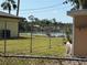Backyard with a partial view of the lake through a chainlink fence at 1625 Meadow Lark Ln, Englewood, FL 34224