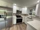 Modern kitchen features stainless steel appliances, white cabinetry and beautiful countertops at 1625 Meadow Lark Ln, Englewood, FL 34224
